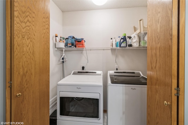 washroom with separate washer and dryer, laundry area, and a textured ceiling