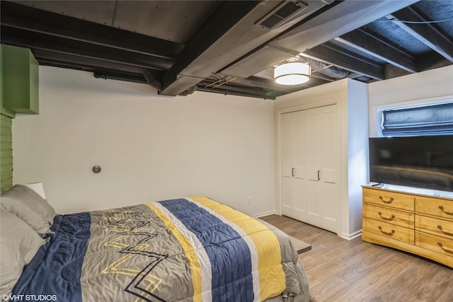 bedroom with baseboards, visible vents, a closet, and light wood-type flooring