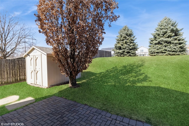 view of yard featuring an outbuilding, a storage unit, and a fenced backyard