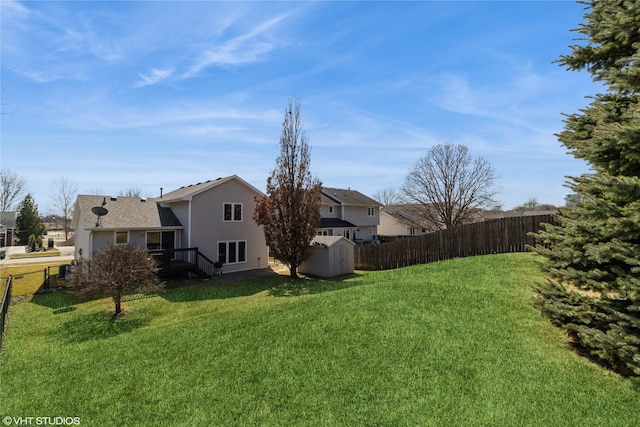 view of yard with an outbuilding, a shed, and fence