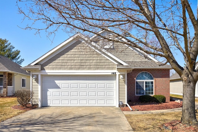 view of front of home featuring a garage, brick siding, roof with shingles, and concrete driveway