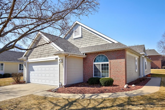 view of front of house with brick siding, an attached garage, driveway, and roof with shingles