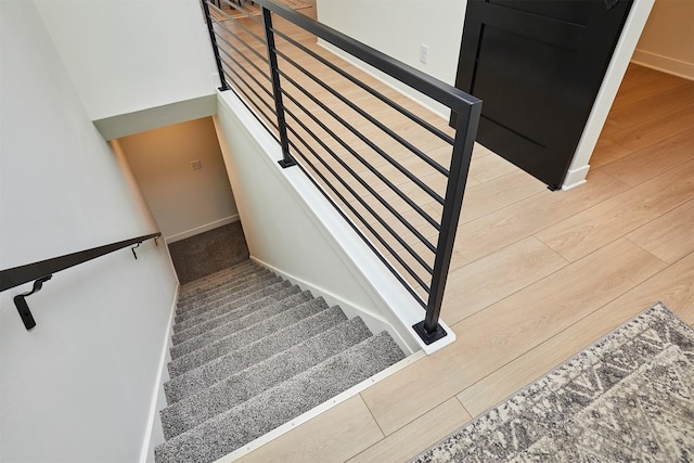 stairs featuring wood finished floors and baseboards