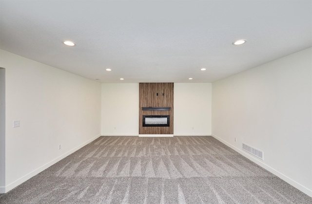 unfurnished living room with visible vents, baseboards, recessed lighting, a fireplace, and carpet flooring