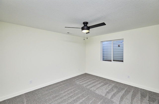 unfurnished room with a ceiling fan, visible vents, baseboards, a textured ceiling, and dark carpet