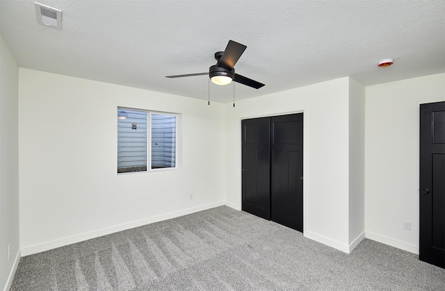 unfurnished bedroom featuring visible vents, baseboards, carpet, and a textured ceiling