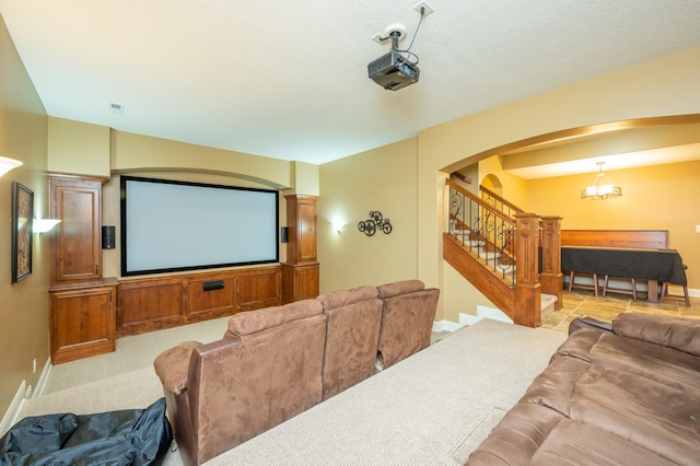 home theater room with a notable chandelier, baseboards, and arched walkways