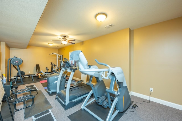 workout area featuring visible vents, a textured ceiling, baseboards, and ceiling fan