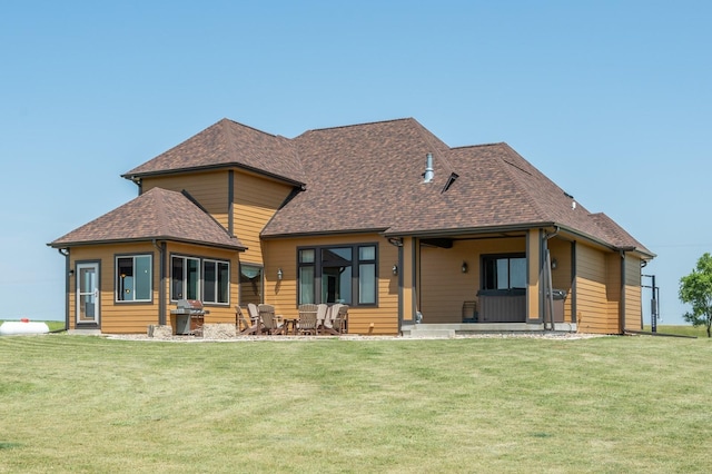 rear view of property with a yard and a shingled roof