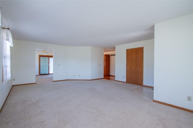 empty room with light colored carpet and baseboards