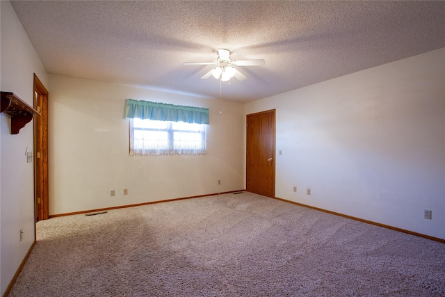 unfurnished room featuring visible vents, a textured ceiling, carpet flooring, baseboards, and ceiling fan