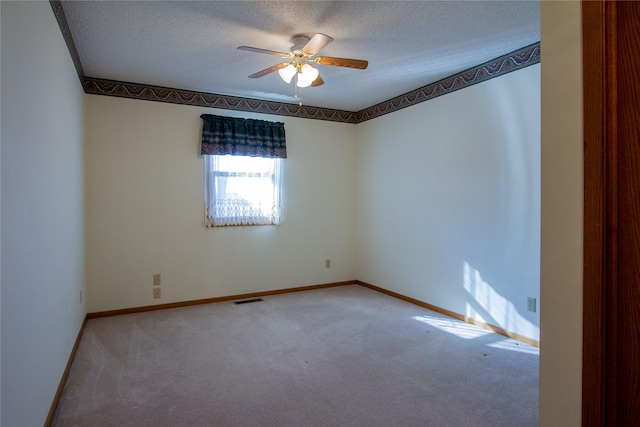 carpeted empty room featuring visible vents, baseboards, a textured ceiling, and ceiling fan