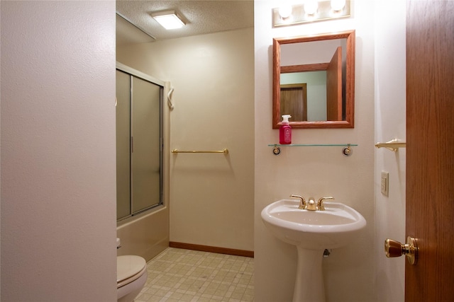 bathroom featuring tile patterned floors, toilet, a textured ceiling, baseboards, and bath / shower combo with glass door