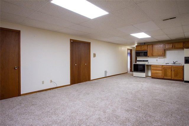 kitchen with electric stove, baseboards, brown cabinets, and black microwave