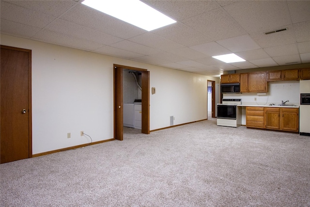 kitchen featuring brown cabinetry, visible vents, a sink, range with electric cooktop, and black microwave