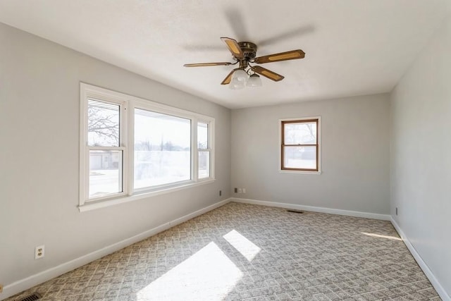 unfurnished room featuring visible vents, baseboards, carpet floors, and a ceiling fan