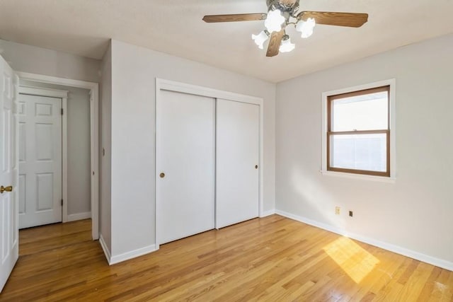 unfurnished bedroom with a closet, baseboards, light wood finished floors, and ceiling fan