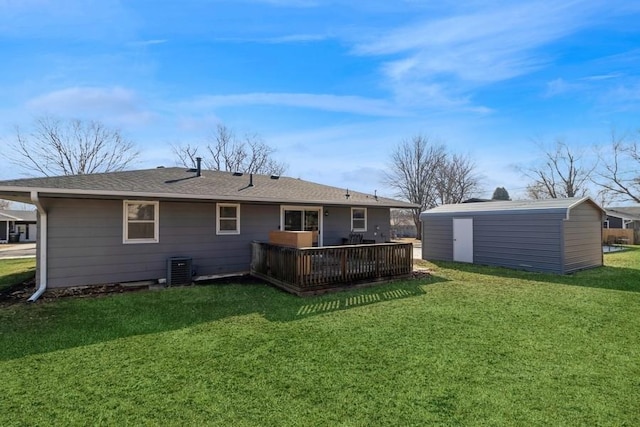 rear view of house with a deck, an outbuilding, central air condition unit, and a lawn