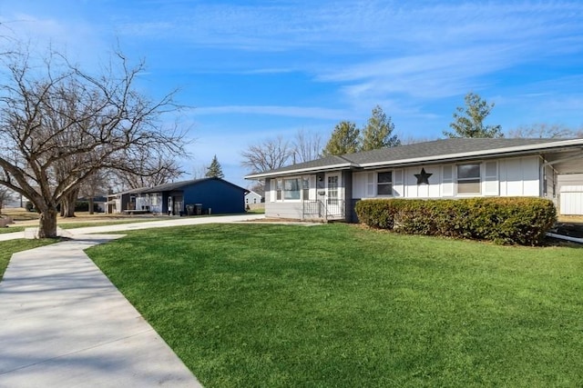 ranch-style home featuring concrete driveway and a front lawn