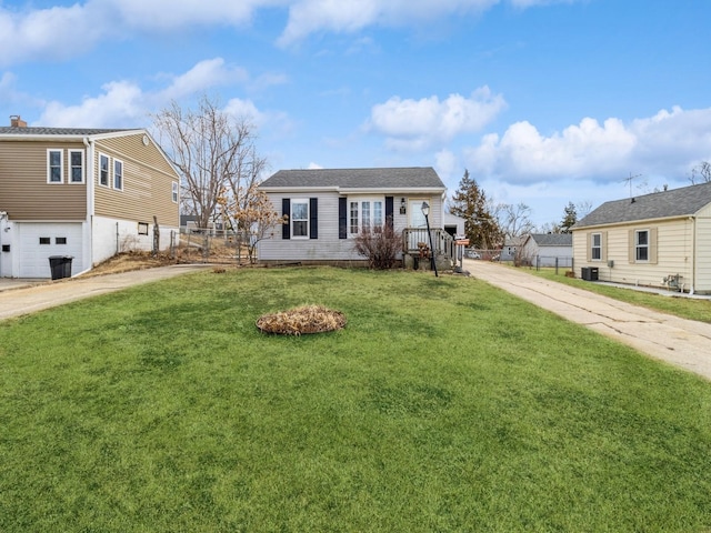 view of front facade featuring driveway, an attached garage, a front lawn, and fence