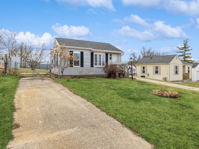 view of front of home featuring fence, concrete driveway, a front lawn, and a gate