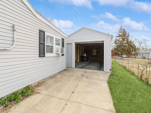 detached garage with concrete driveway and fence