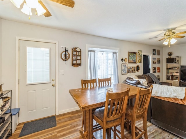 dining room with baseboards, light wood-type flooring, and ceiling fan