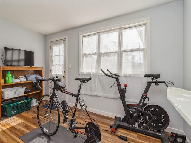 workout area featuring baseboards and wood finished floors