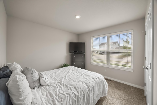 carpeted bedroom featuring visible vents and baseboards