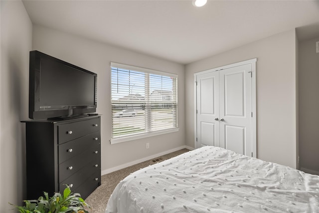 bedroom with carpet flooring, baseboards, and a closet