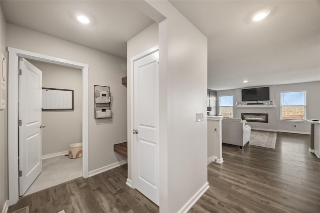 corridor featuring recessed lighting, baseboards, and dark wood-style flooring