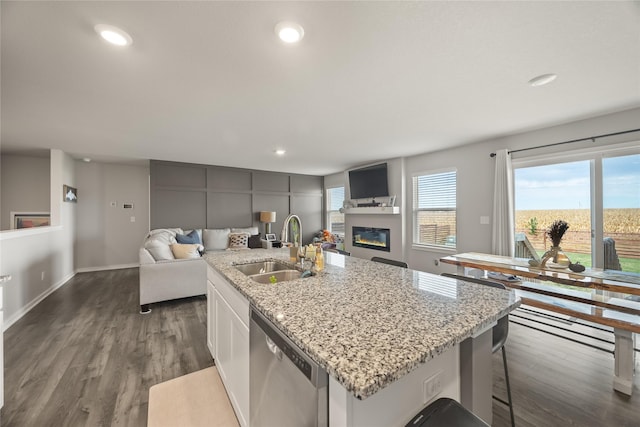 kitchen featuring dark wood finished floors, open floor plan, dishwasher, and a sink