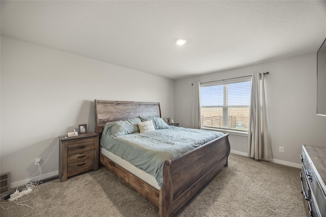 bedroom with baseboards and light colored carpet