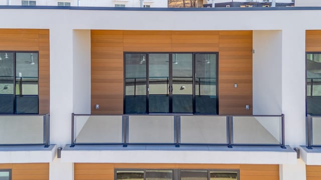 entrance to property featuring stucco siding and a balcony