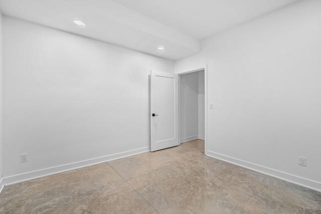 empty room featuring recessed lighting, baseboards, and concrete flooring