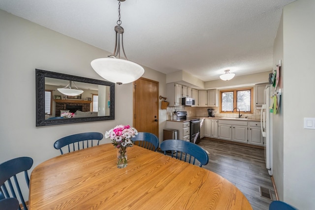 dining room featuring visible vents, a textured ceiling, and dark wood-type flooring