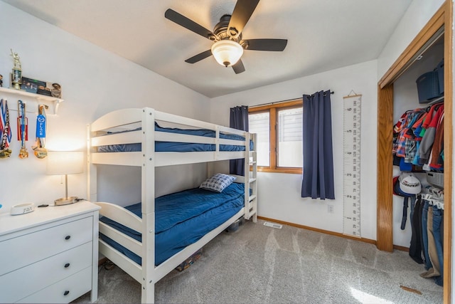 carpeted bedroom featuring baseboards, a closet, and ceiling fan