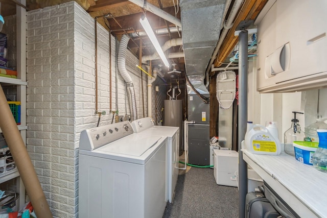 laundry area featuring laundry area, brick wall, and washer and clothes dryer