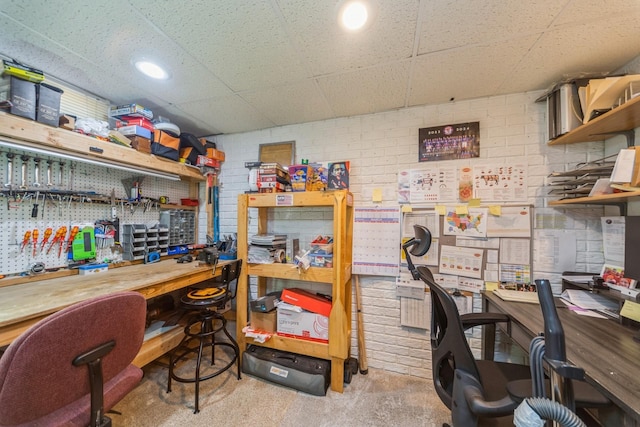 office featuring a paneled ceiling and a workshop area