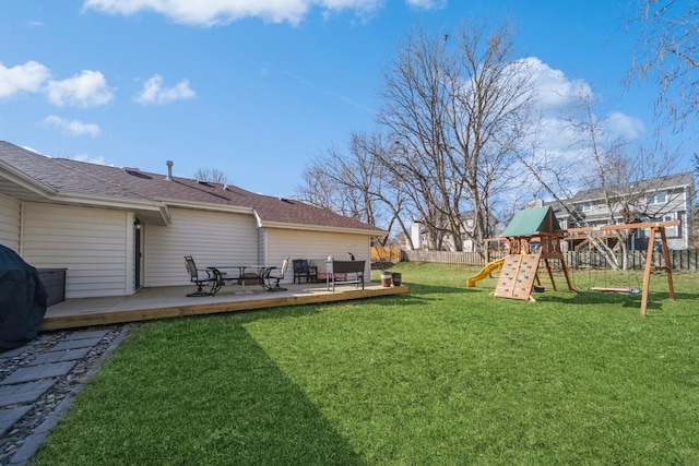 view of yard with a playground, fence, and a wooden deck