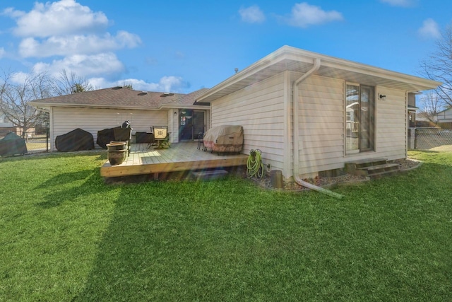 back of house featuring a lawn, a deck, and fence