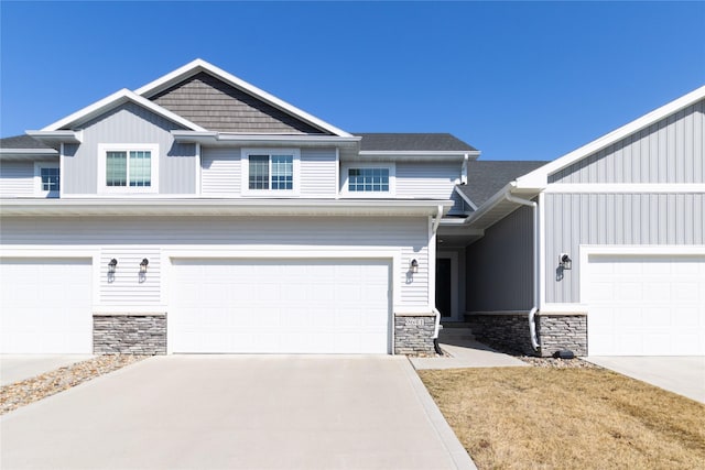 craftsman inspired home with stone siding and driveway