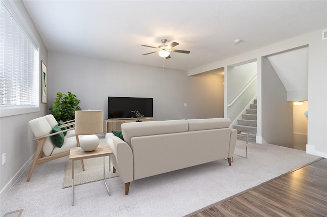 living area with visible vents, baseboards, ceiling fan, stairs, and wood finished floors