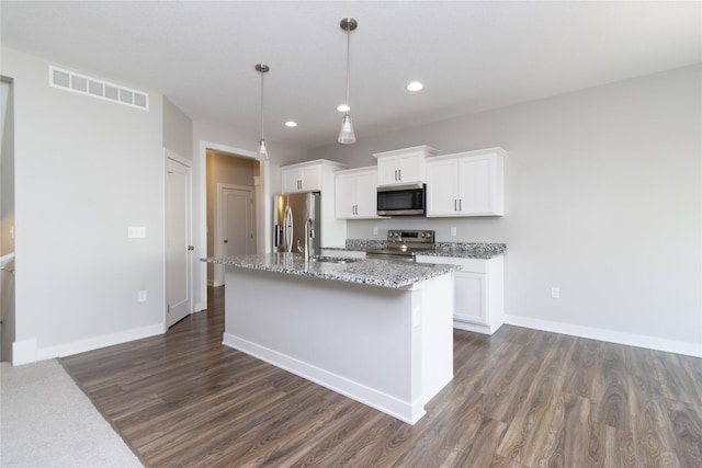 kitchen with visible vents, a kitchen island with sink, a sink, white cabinets, and appliances with stainless steel finishes