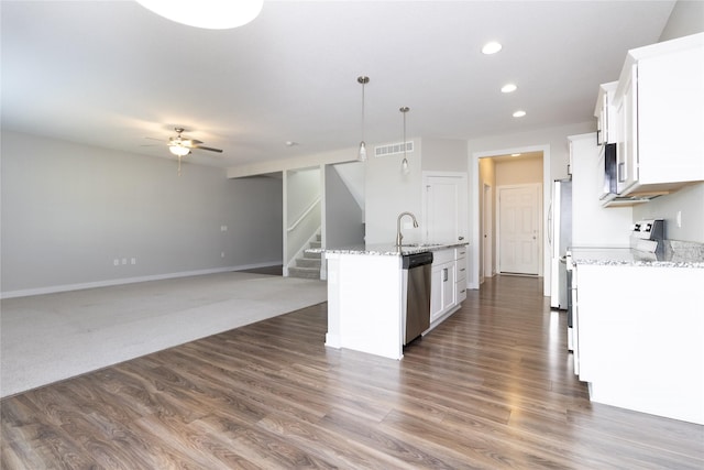 kitchen featuring a kitchen island with sink, a sink, stainless steel dishwasher, white cabinetry, and range