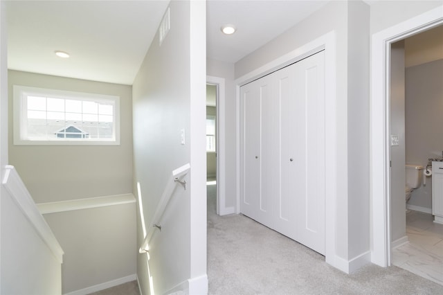 corridor featuring an upstairs landing, visible vents, and baseboards