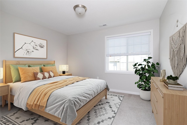 bedroom with light colored carpet, visible vents, and baseboards