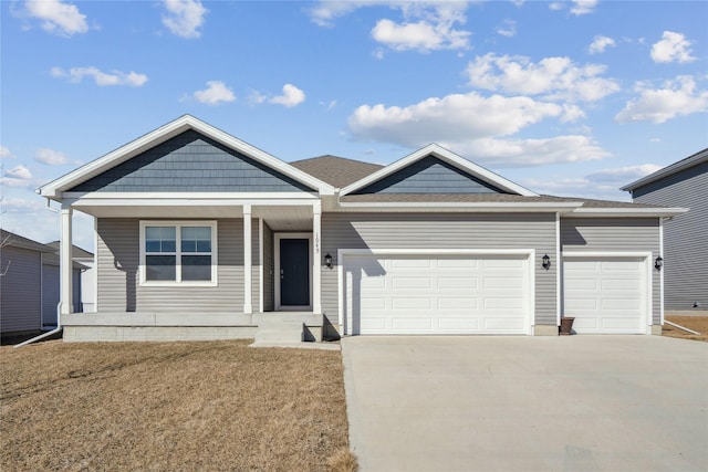 view of front of home with driveway, covered porch, and an attached garage