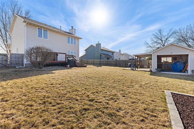 rear view of property featuring a deck, a yard, a fenced backyard, and a chimney