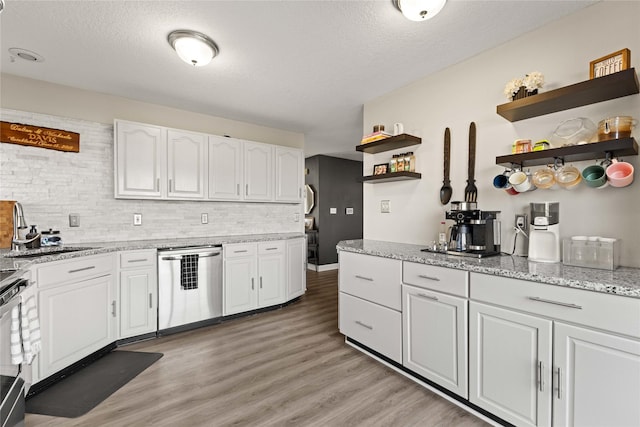 kitchen with open shelves, a sink, white cabinets, dishwasher, and light wood-type flooring